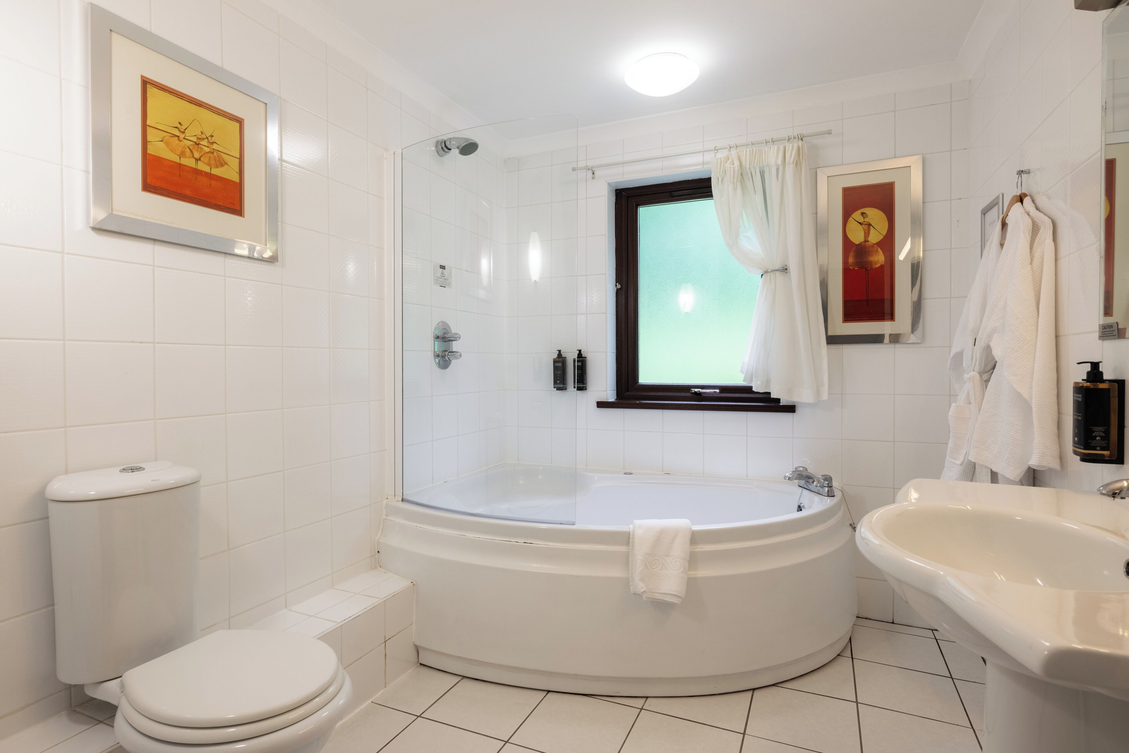 A bathroom with a bathtub, a toilet, a sink, and a shower.