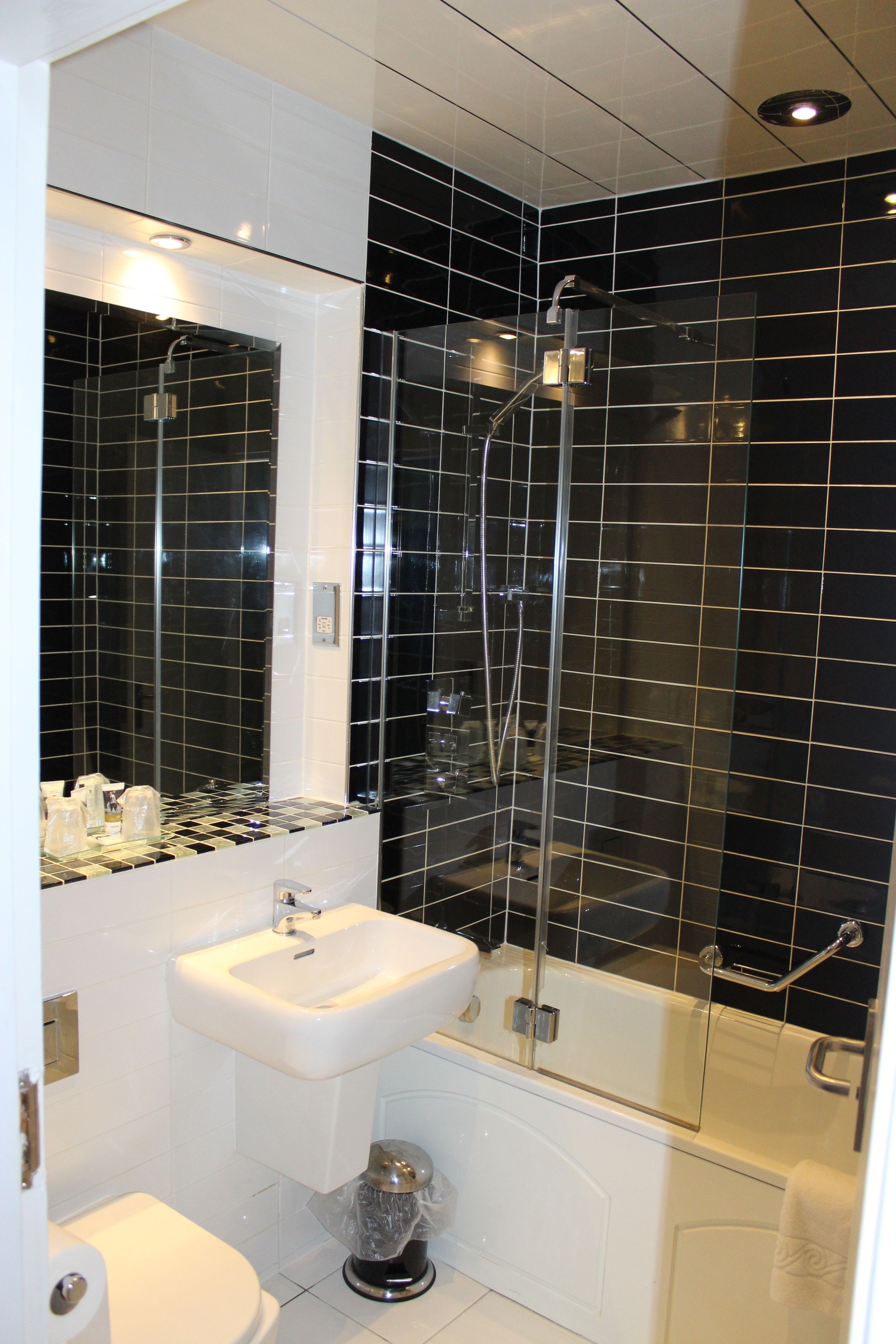 Une salle de bain moderne avec une douche à parois de verre, un lavabo blanc et des toilettes.