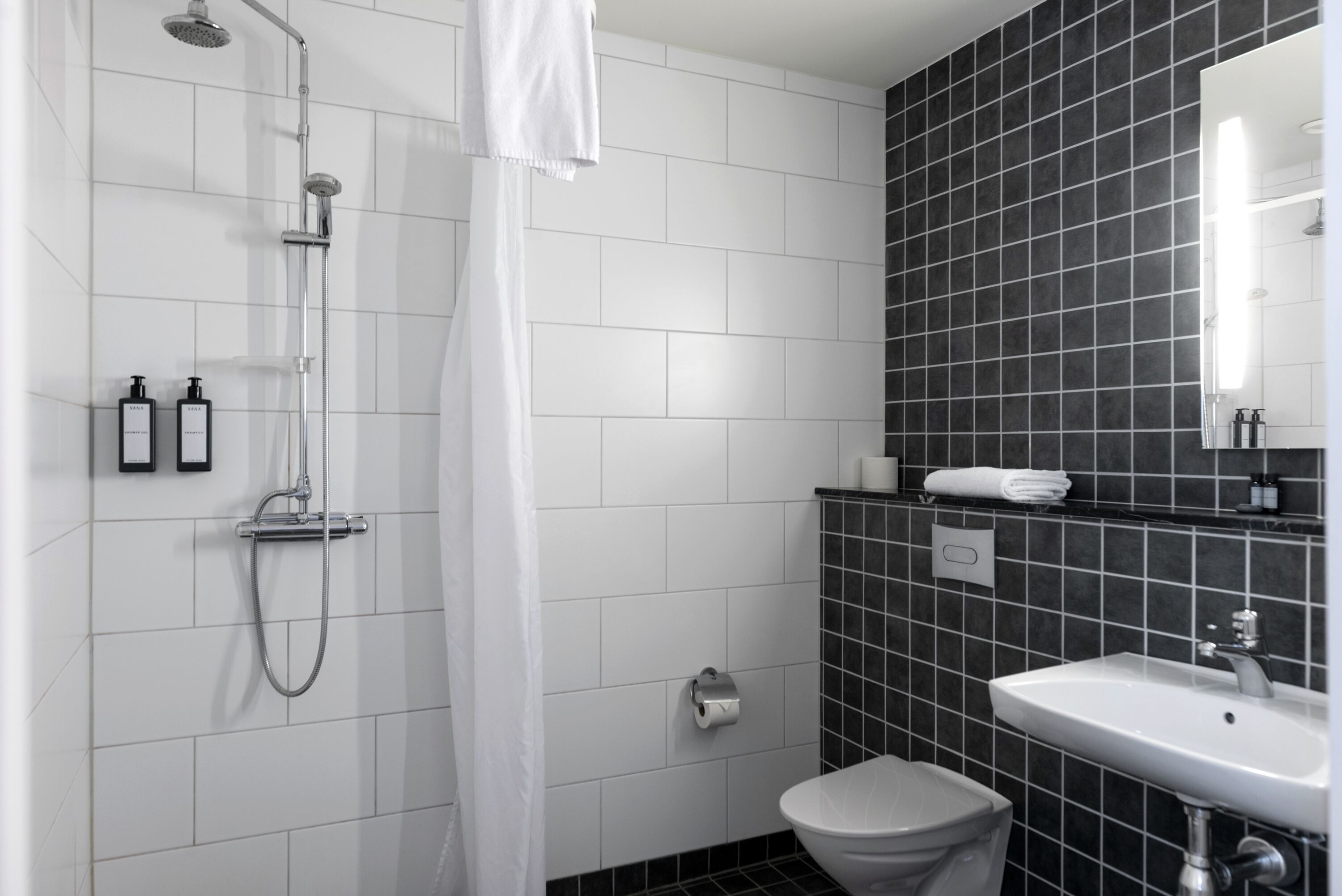 Une salle de bain moderne équipée d’une douche, de toilettes et d’un lavabo.