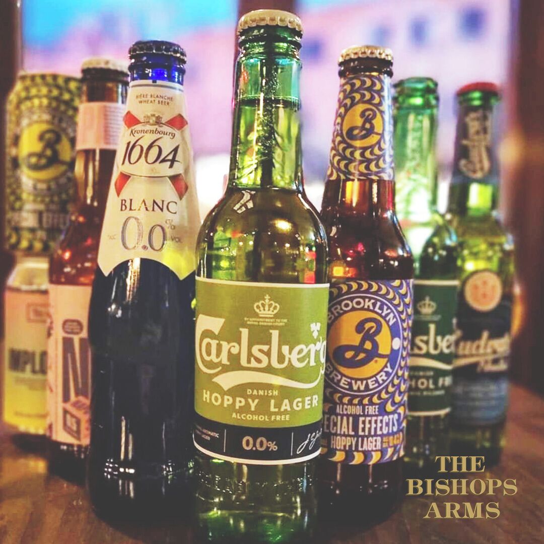 Variedad de botellas de cerveza sobre una superficie de madera.