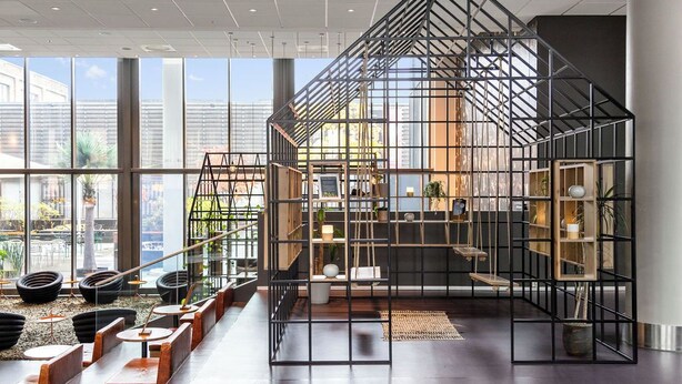 A modern interior with a geometric metal structure, seating areas, and a view through large windows. - Comfort Hotel Union Brygge - Drammen (Drammen)