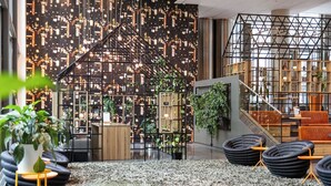 A modern interior with a cityscape wall, a staircase, and seating areas. - Comfort Hotel Union Brygge - Drammen (Drammen)