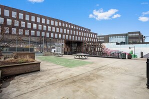 A modern building with a courtyard featuring a hopscotch court, seating areas, and a sports field. - Comfort Hotel Union Brygge - Drammen (Drammen)