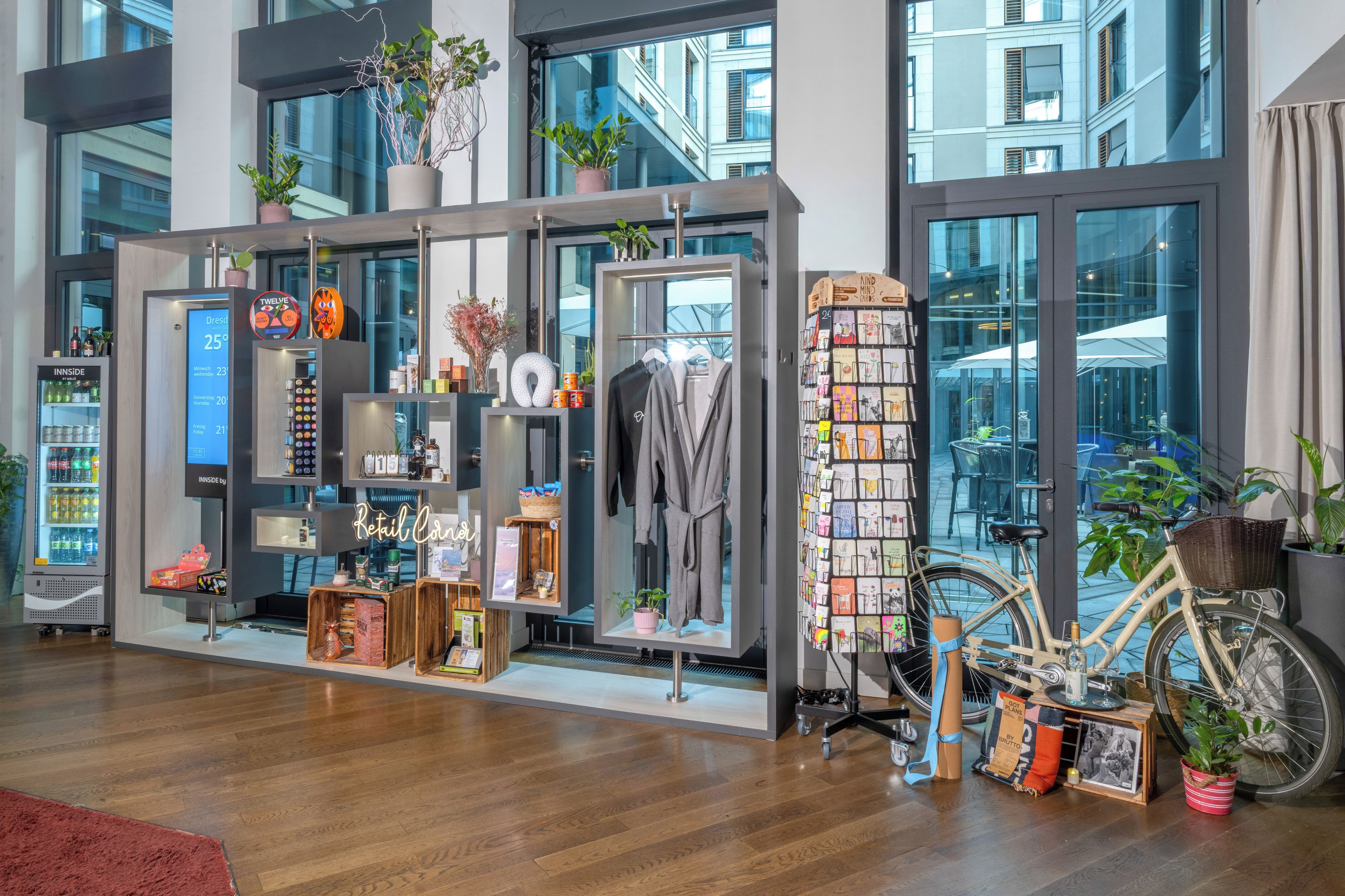 Un magasin moderne avec un plancher en bois, une variété de produits exposés sur des étagères et un vélo en premier plan.