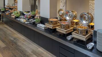 Een buffetopstelling met diverse gerechten en bestek.