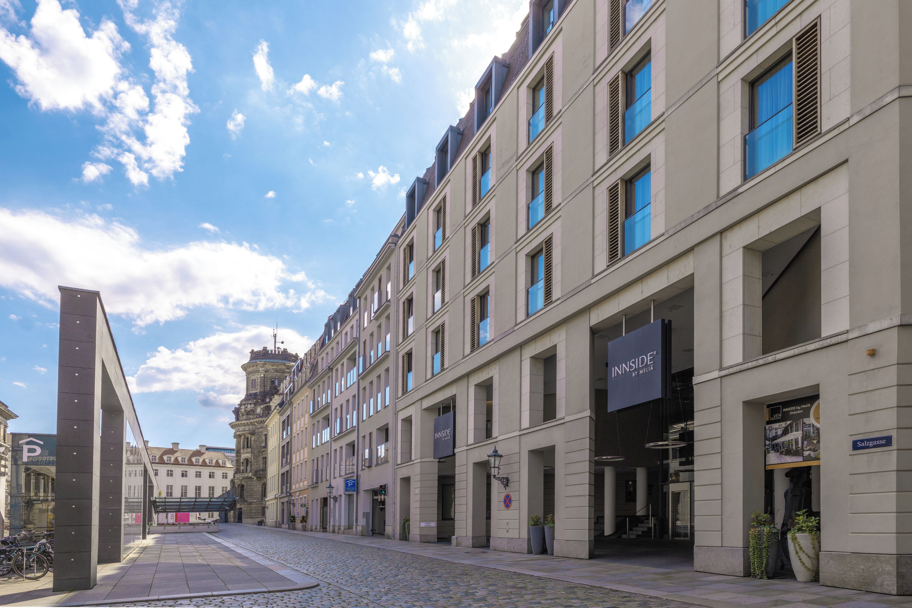 A street view with a row of buildings, including a hotel with a sign 'INNSIDE BY MELIA'.