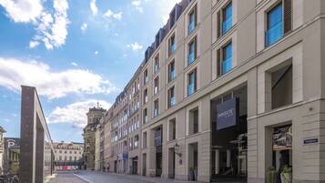 A street view with a row of buildings, including a hotel with a sign 'INNSIDE BY MELIA'.