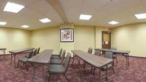 A conference room with six tables and chairs, a framed picture on the wall, and a door with a sign. - Holiday Inn Express Hotel & Suites AMITE by IHG (Amite)