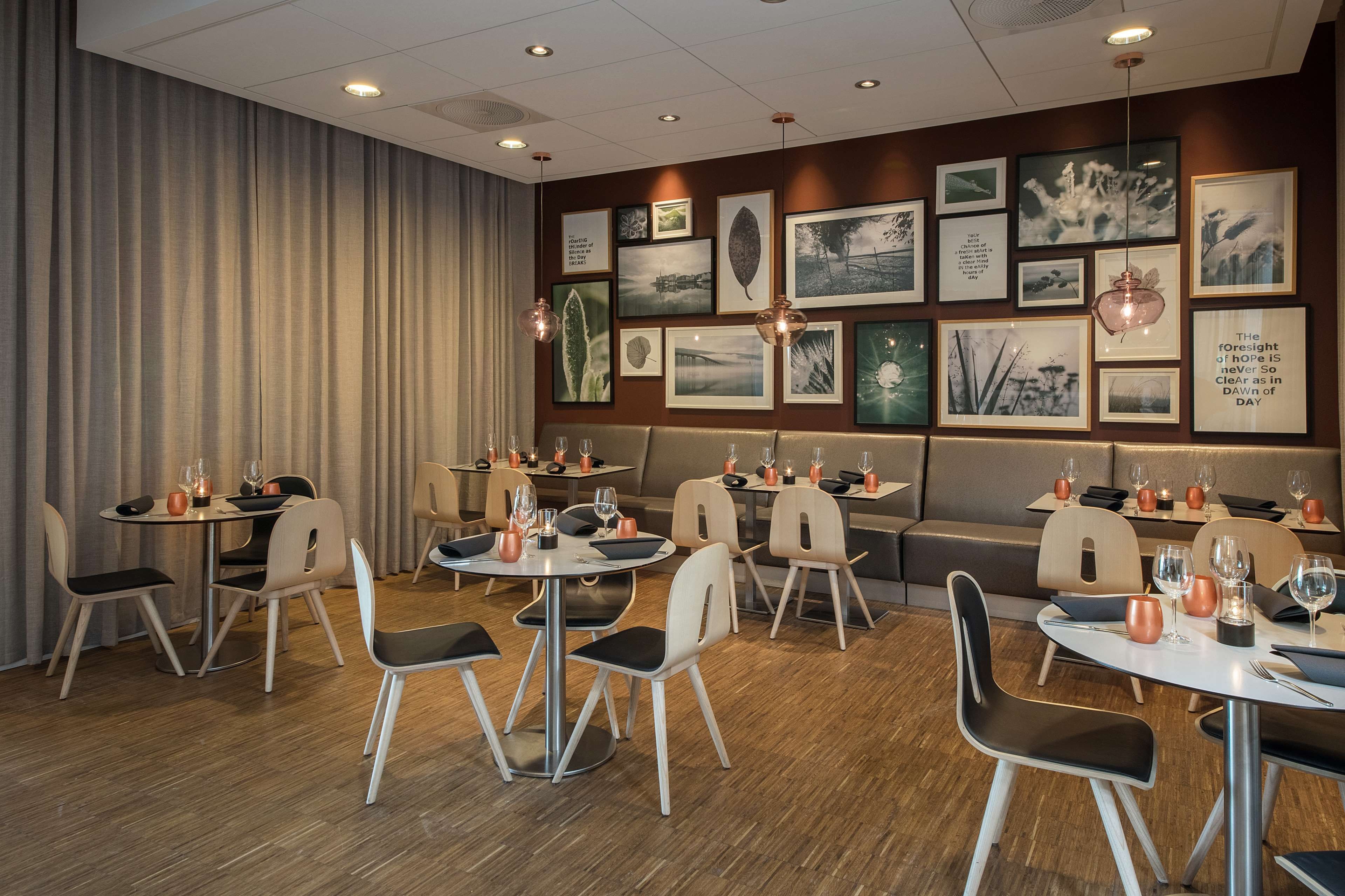 A modern dining area with round tables, chairs, and a sofa.