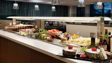 A buffet with various food items, including cheeses, fruits, and salads.