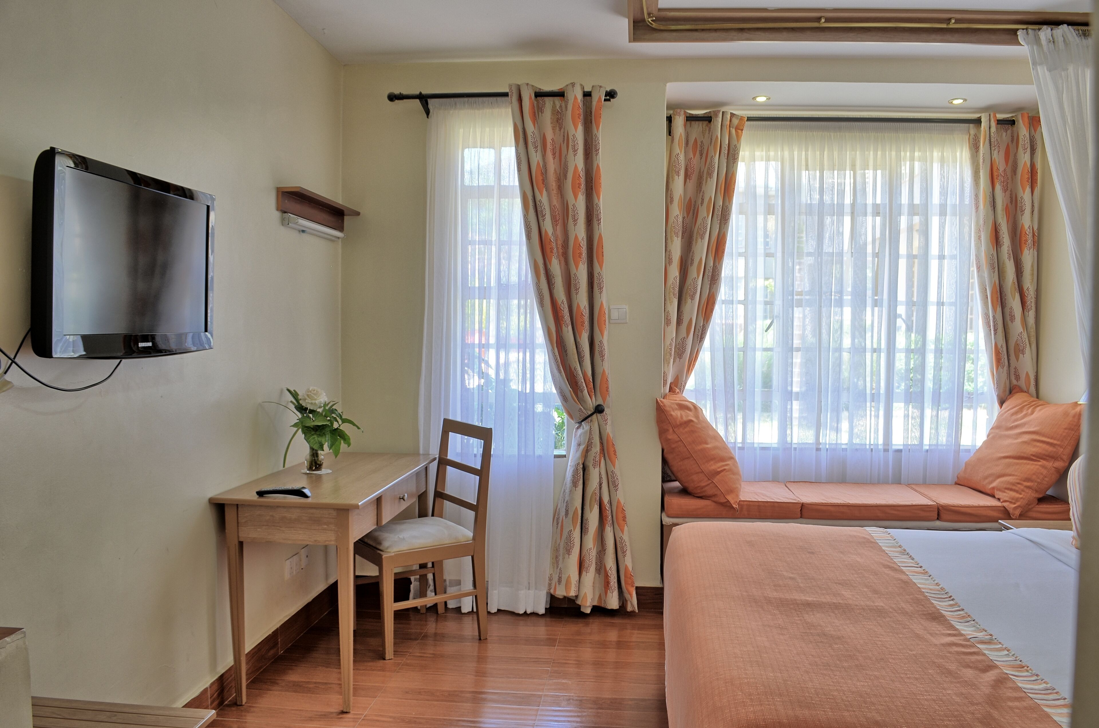 A bedroom with a bed, a desk, and a chair.