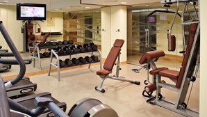 A gym with treadmills, weight machines, and a TV screen. - ibis Dubai Al Rigga (Dubai)