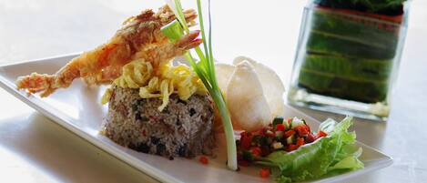 Une assiette contenant du riz, des légumes et un plat frit.