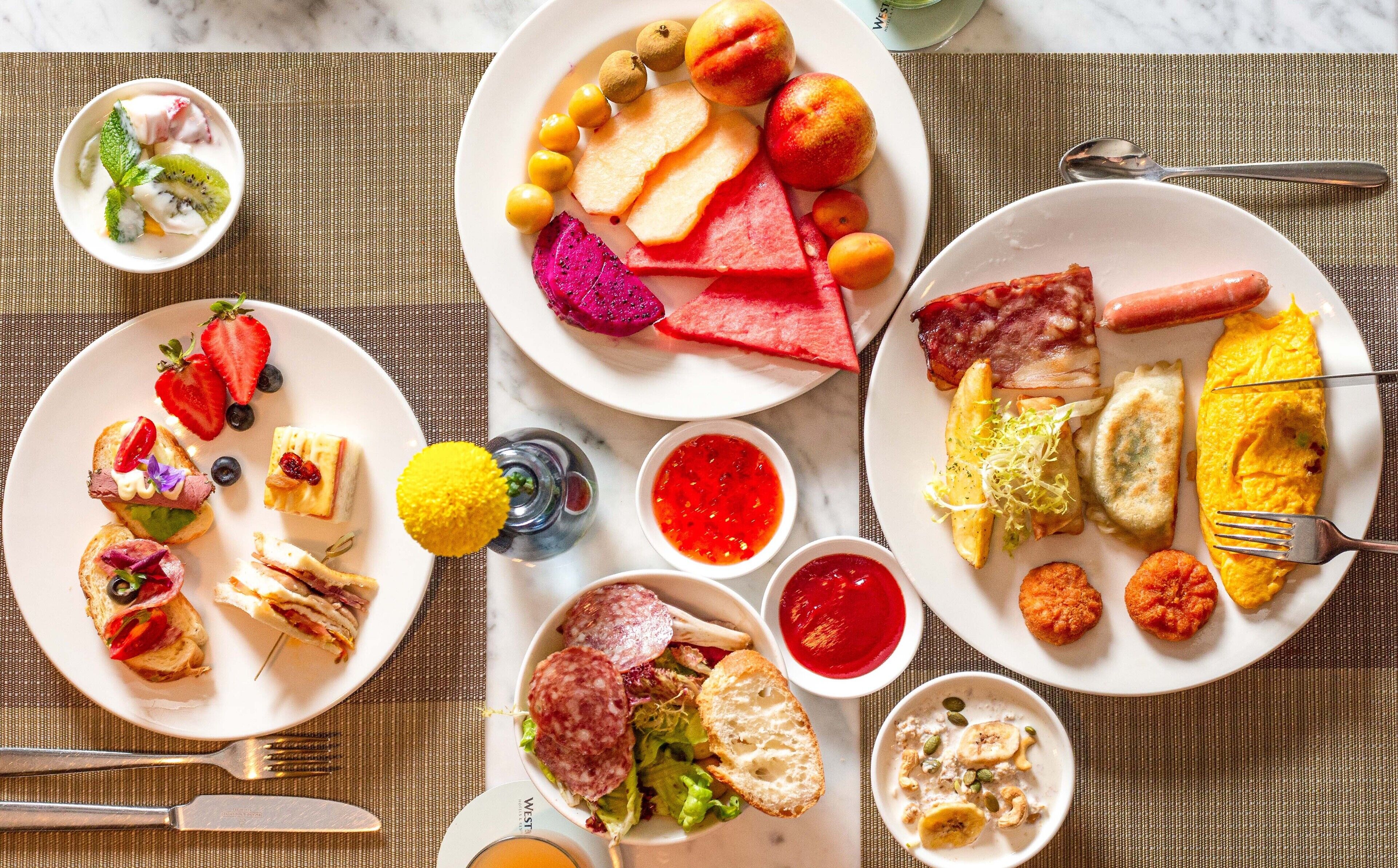 A variety of breakfast dishes including toast, eggs, and fruit on a table.