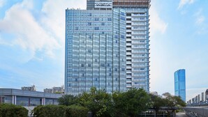 A modern high-rise hotel with a prominent 'WESTIN' sign, featuring a glass facade and multiple floors.