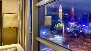 A hotel room with a large window overlooking a brightly lit urban area at night, featuring illuminated buildings and a tower. - The Westin Shenzhen Nanshan (Shenzhen)