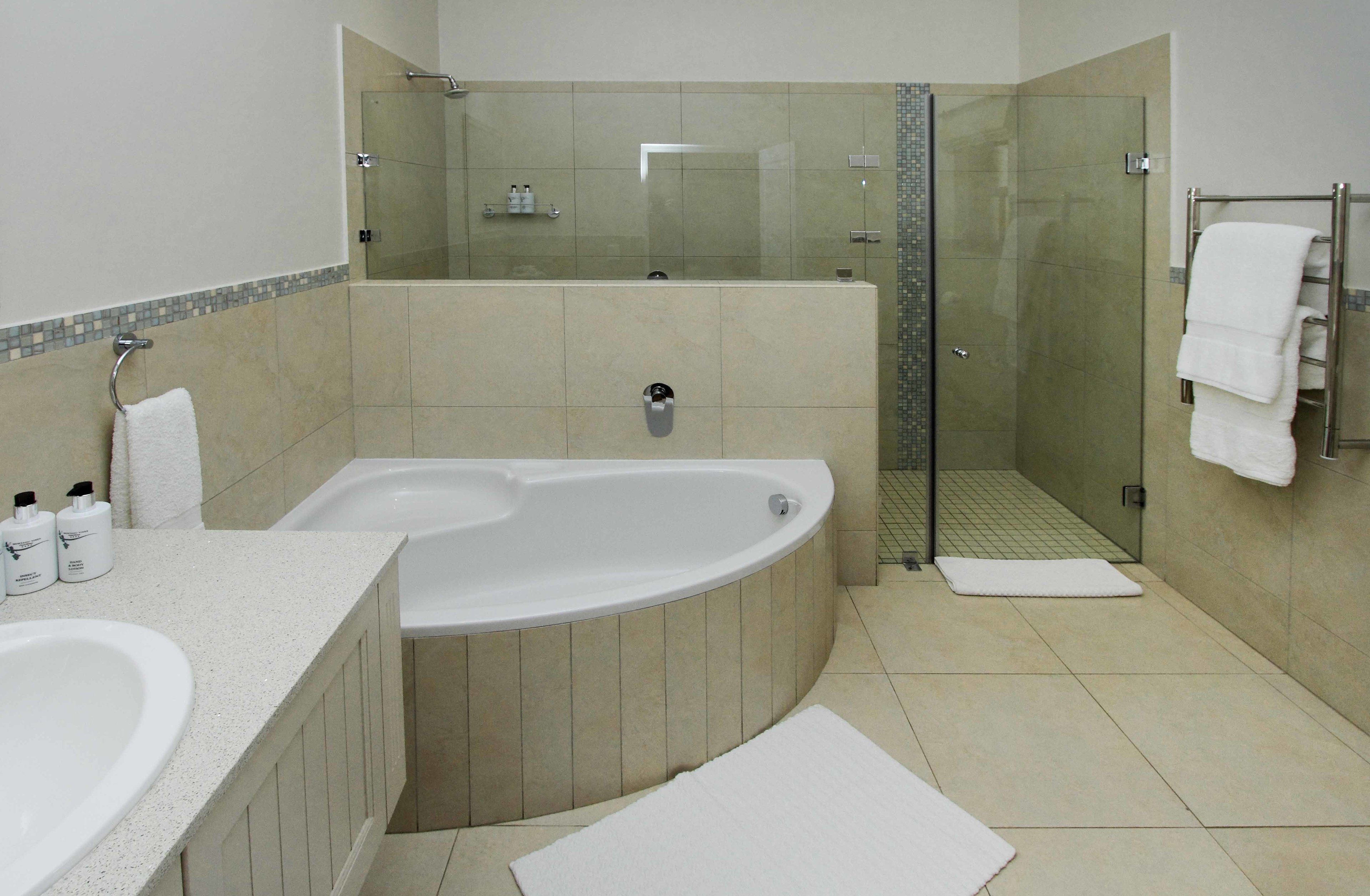 A modern bathroom with a freestanding bathtub, a glass-enclosed shower, and a vanity with a sink and towel rack.