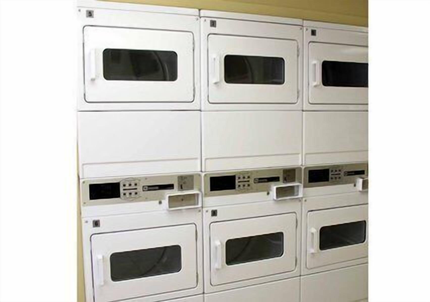 A row of white lockers with black handles and a control panel with buttons and a display.