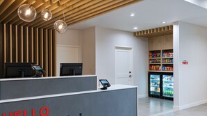 Una reception con un cartello 'HELLO Weatherford', un chiosco digitale e una vetrina refrigerata per snack.