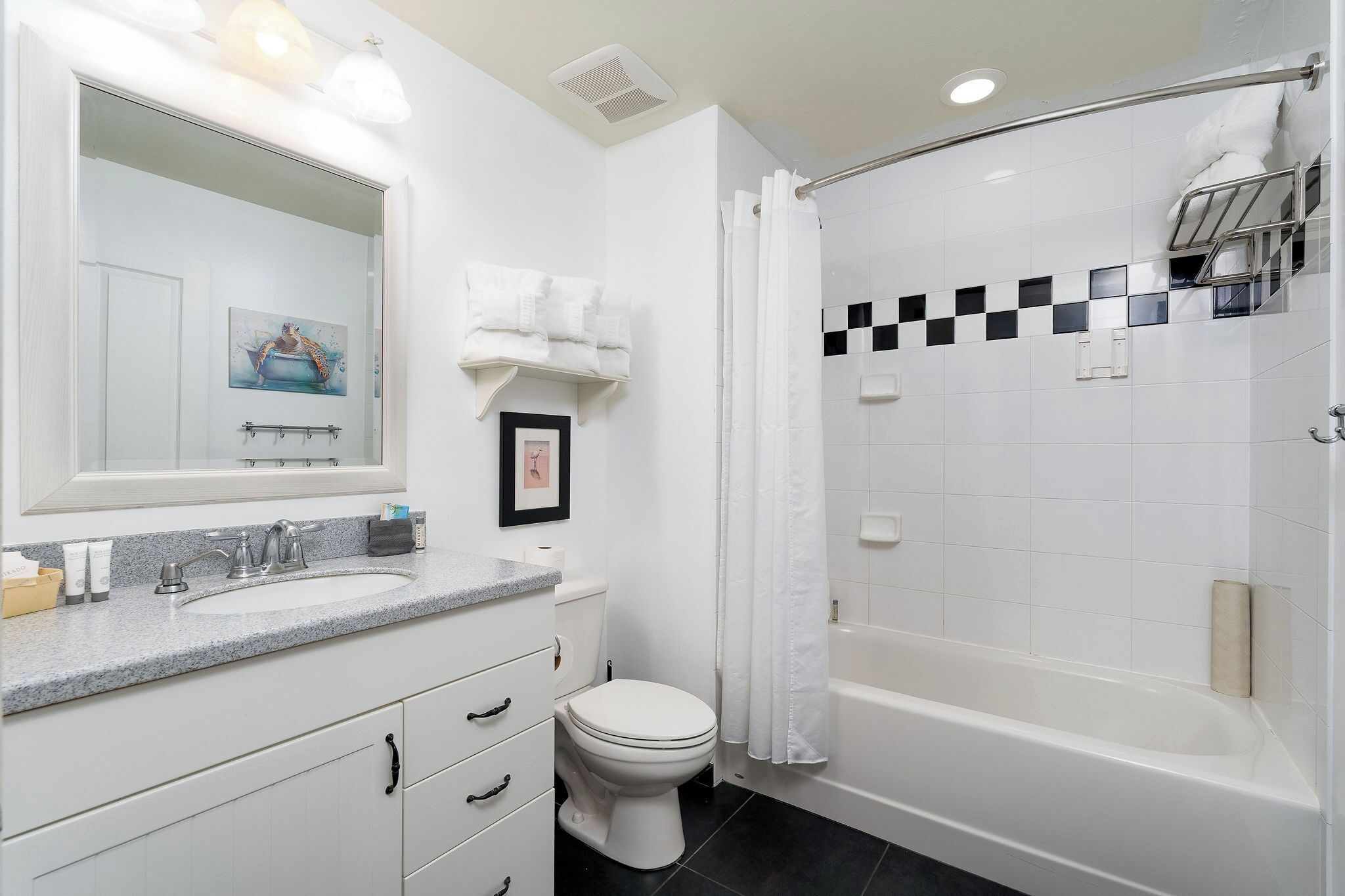 A modern bathroom with a white sink, toilet, and bathtub.