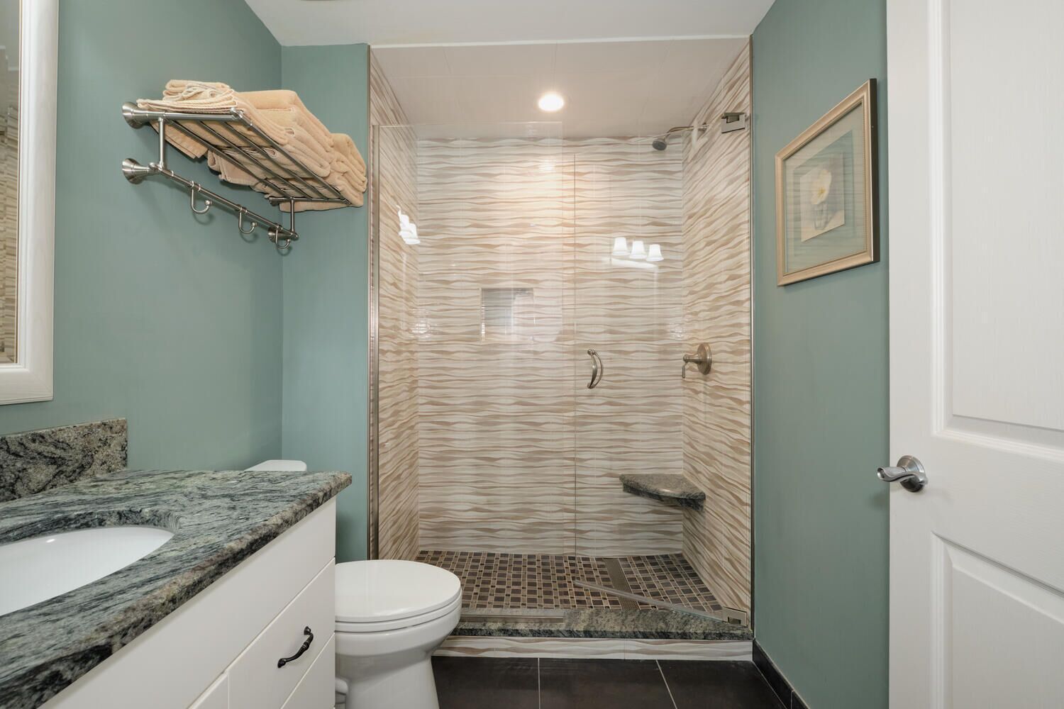 A bathroom with a shower, toilet, and sink.