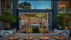 A modern hotel lobby with a bar area, seating arrangements, and indoor plants. - W Hollywood (Los Angeles)