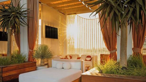 A modern bedroom with a large bed, wooden headboard, and a TV mounted on the wall. - W Hollywood (Los Angeles)