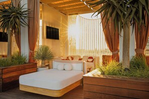 A modern bedroom with a large bed, wooden headboard, and a TV mounted on the wall.