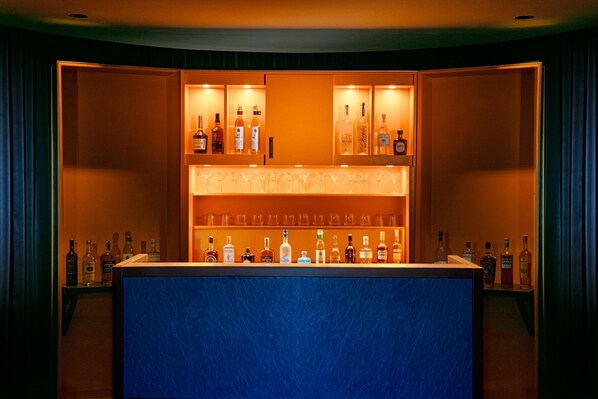 A bar area with shelves of liquor bottles and glasses.