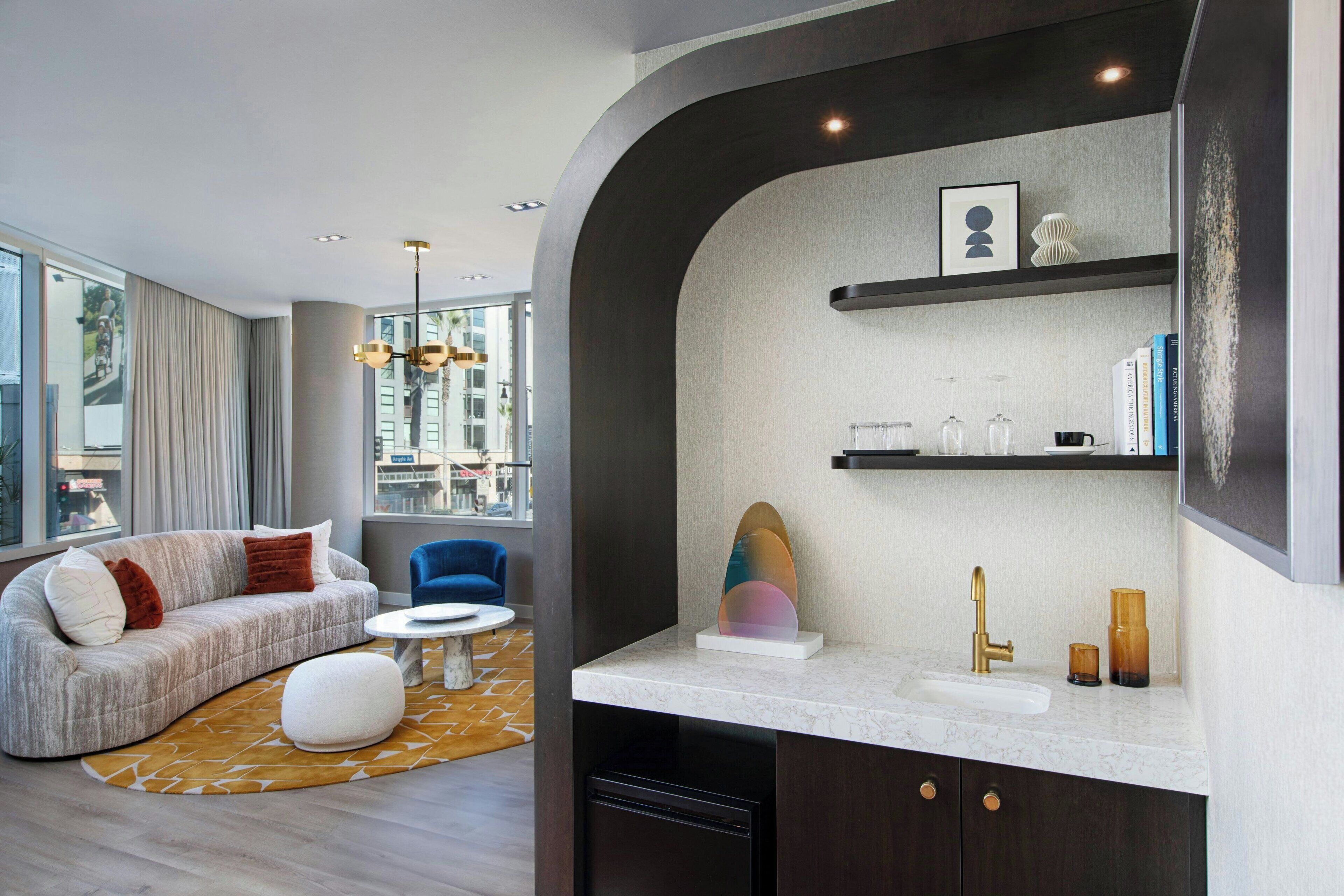 A modern living room with a sofa, a coffee table, and a view of the city.