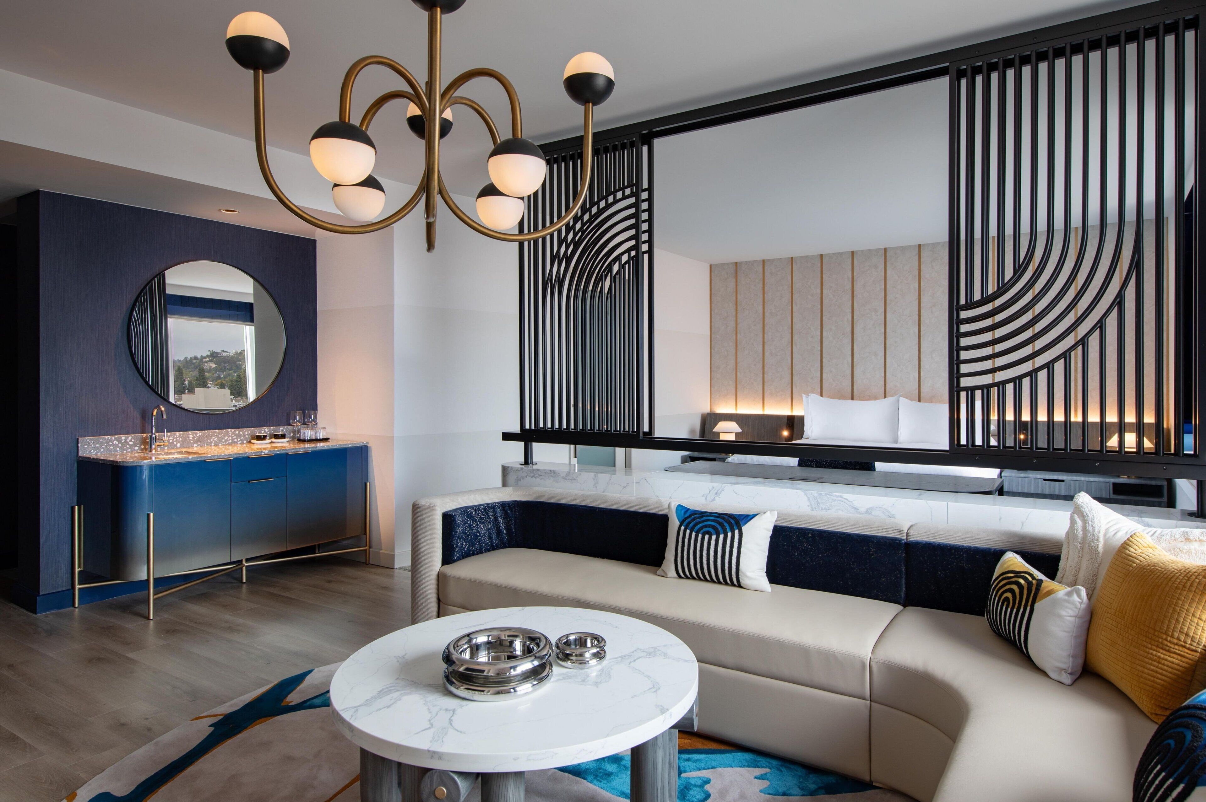 A modern living room with a sofa, a round coffee table, and a decorative mirror.