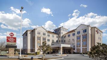 Um hotel Best Western Plus com um pátio central, várias entradas e céu claro.