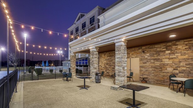 An outdoor patio area with string lights, stone pillars, and outdoor seating. - Best Western Plus Rose City Conference Center Inn (Thomasville)
