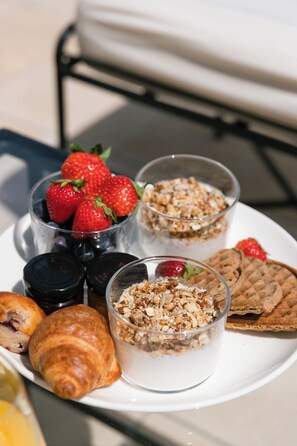 A breakfast plate with strawberries, granola, a croissant, and a waffle. - Heritage Hotel Tisno (Tisno)