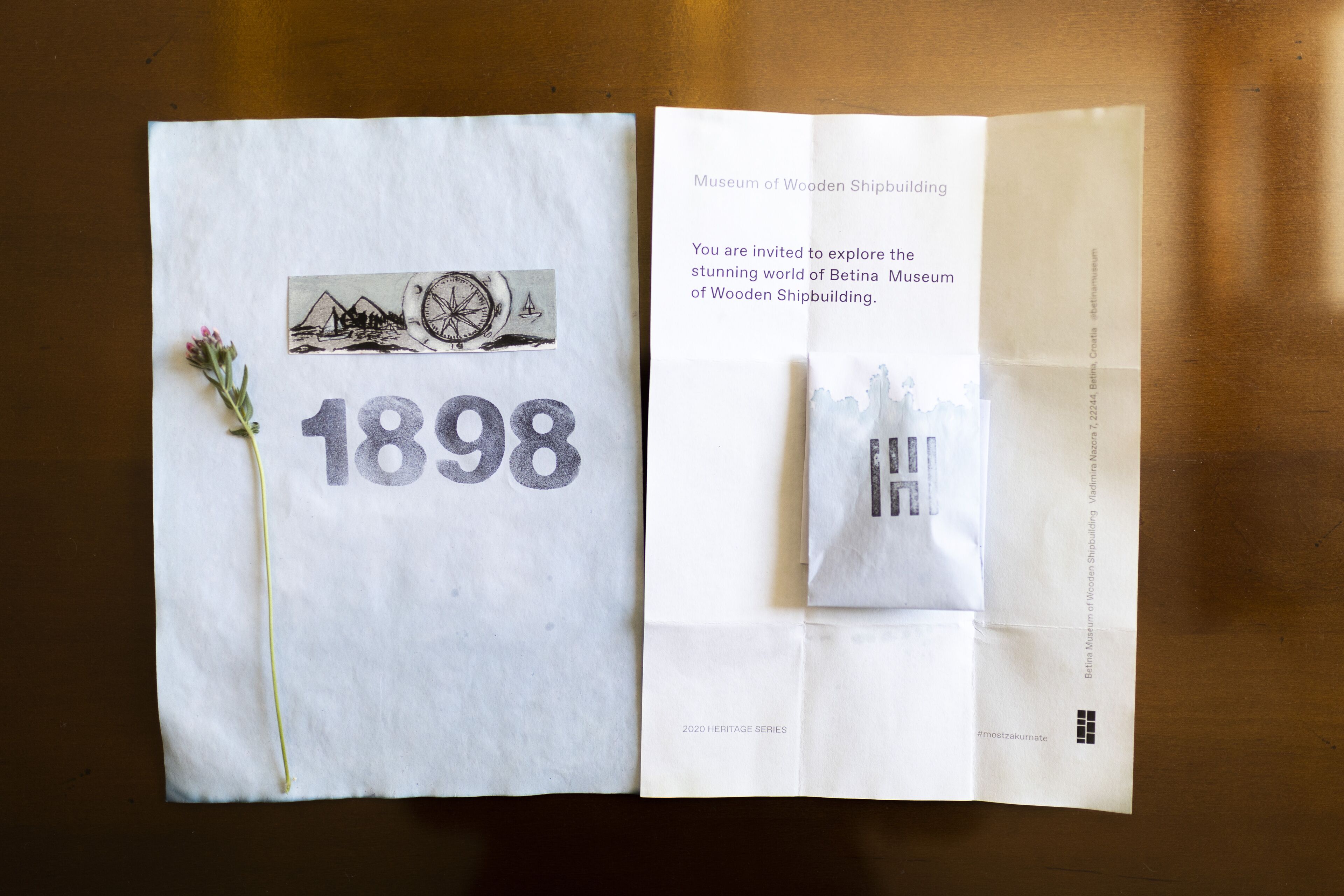 Un folleto abierto del Museo de la Construcción Naval en Madera, con la fecha '1898' y una ilustración de una brújula.