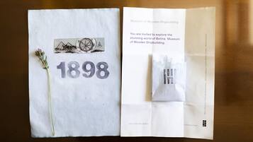 Un folleto abierto del Museo de la Construcción Naval en Madera, con la fecha '1898' y una ilustración de una brújula.