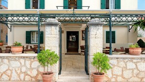 Un hotel con fachada clásica, entrada principal y mesas al aire libre.