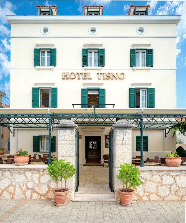 A hotel with a classic facade, a central entrance, and outdoor seating. - Heritage Hotel Tisno (Tisno)