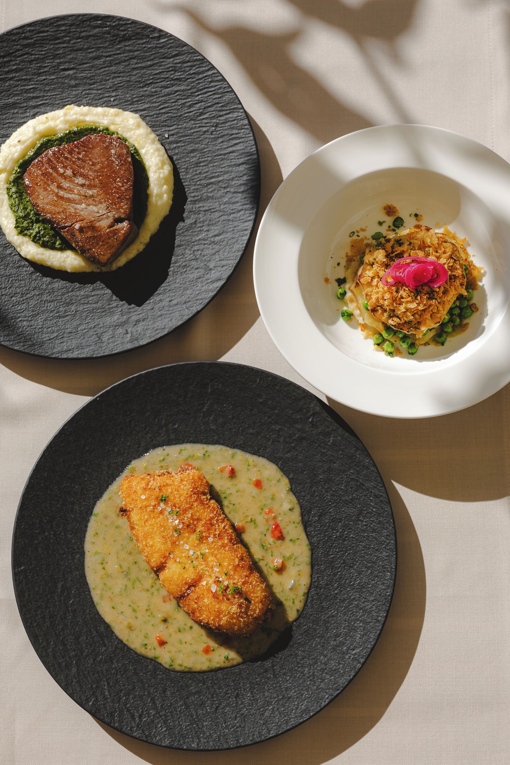 Tres platos de comida sobre una mesa.