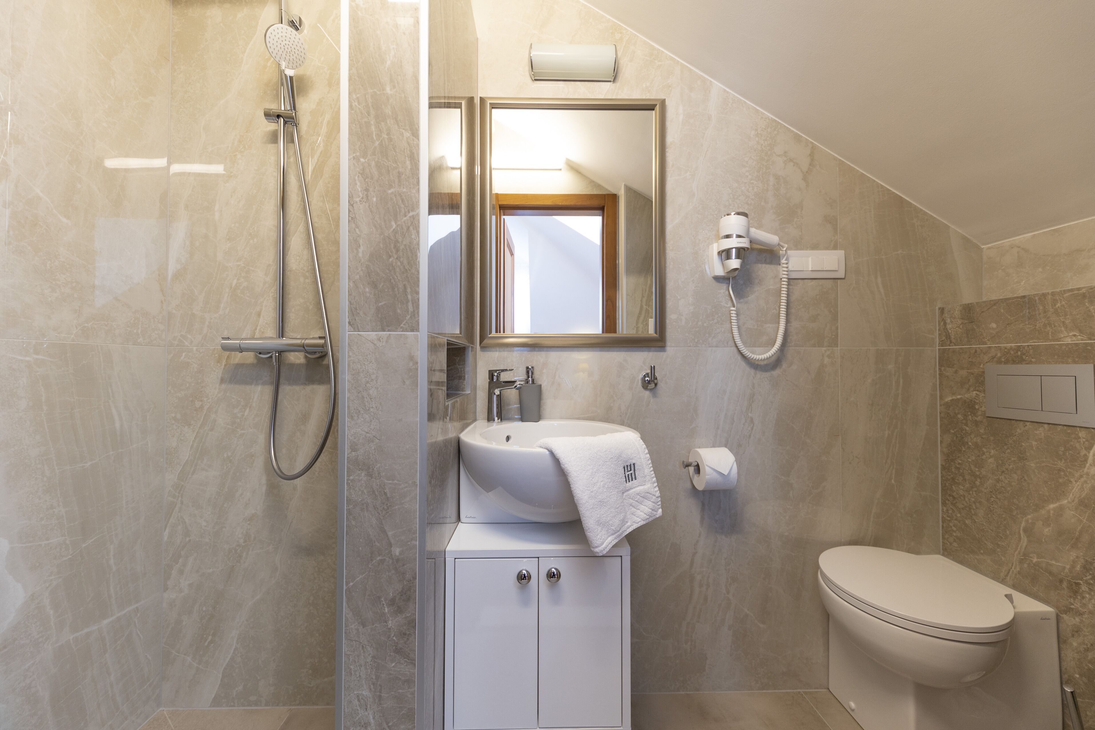 Une salle de bain moderne équipée d’une douche, d’un lavabo et de toilettes.
