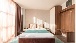 Habitació moderna amb un llit gran, armari de fusta i una panxa.