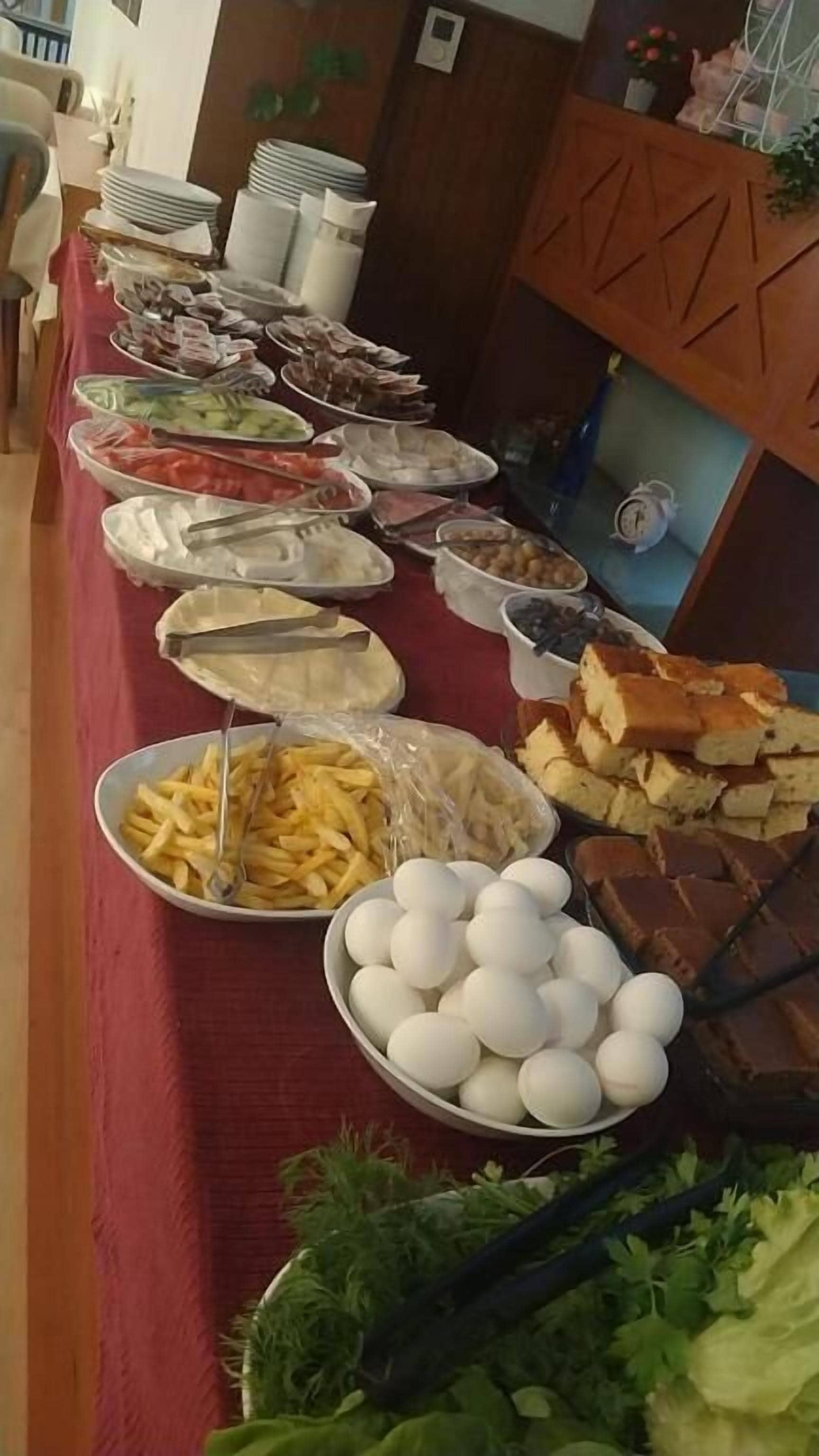 Una mesa de buffet con diversos alimentos, como huevos, pan y otras preparaciones.