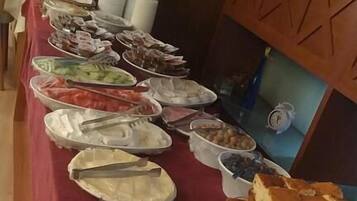 Una mesa de buffet con diversos alimentos, como huevos, pan y otras preparaciones.
