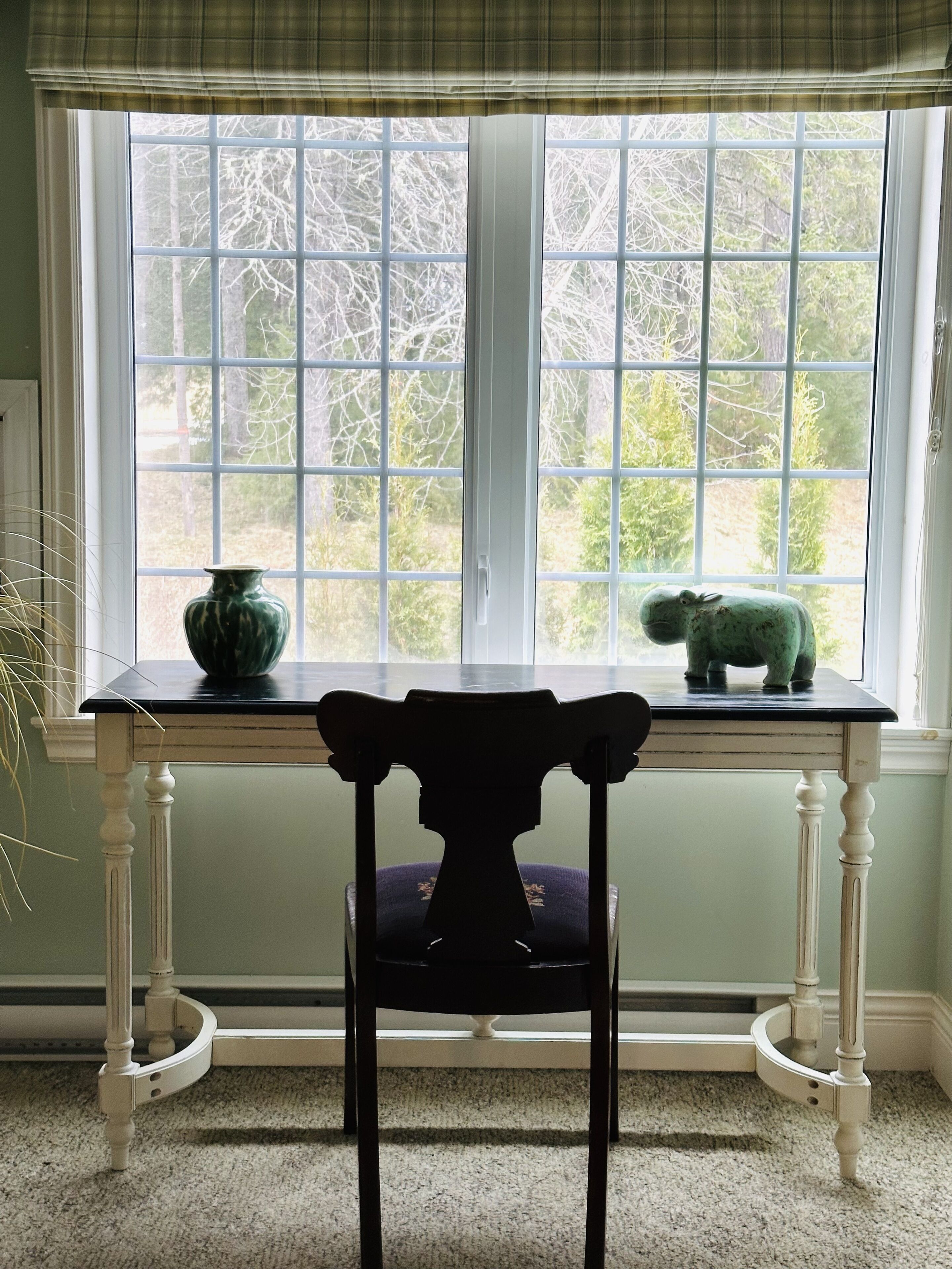Una habitación con ventana, una mesa y una silla.
