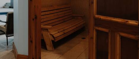 A steam room with wooden benches and a sign indicating its use.