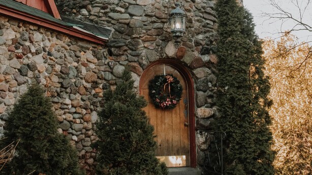 A stone tower with a wooden door, windows, and a lantern.