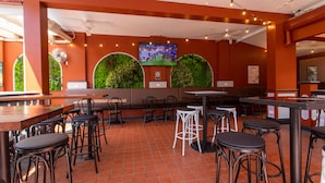 A restaurant interior with red walls, green wall decorations, and multiple seating areas including bar stools and tables. - Royal Exhibition Hotel (Surry Hills)