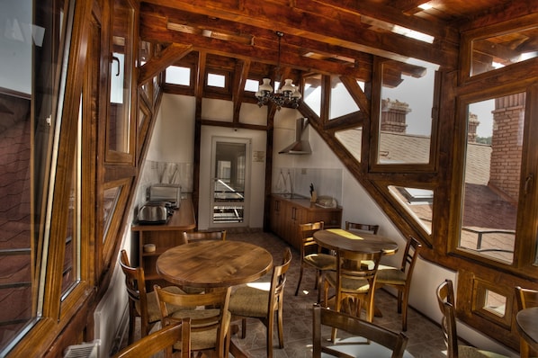 A rustic dining area with wooden furniture and large windows.