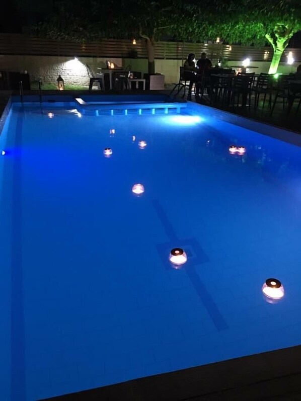 Una piscina con múltiples luces alrededor del borde.