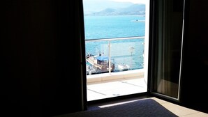 A balcony with a view of a body of water, a dock, and boats. - Kipseli Hotel (Volos)